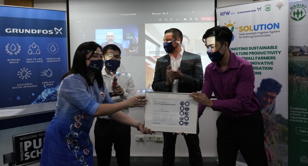 Grundfos Philippines receives a diploma and a statuette. From left: Karen Kristy Ople, Gilbert Luna, Jonathan Breton, and Jerrald Santos.