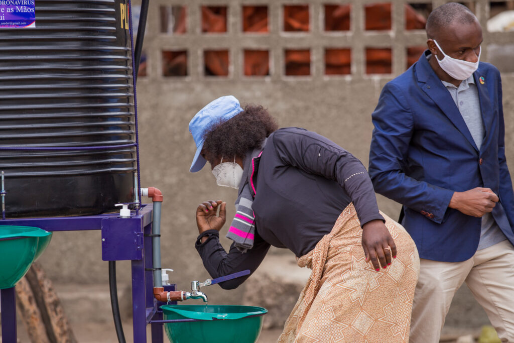 Market vendor Mariana washes her hands at a public hand washing station.