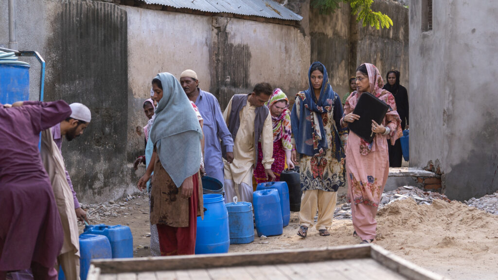 Scene from INTO DUST: Women standing in line to access water.