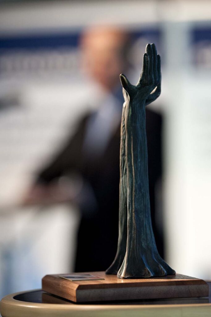 Statuetten ligner en hånd der peger opad mod himlen.