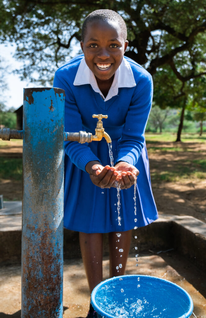 Munira tapper vand fra skolens vandpost.
