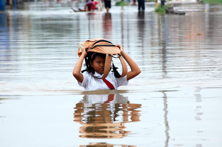 Portrait Of Girl With Bag On Head Walking In Water.