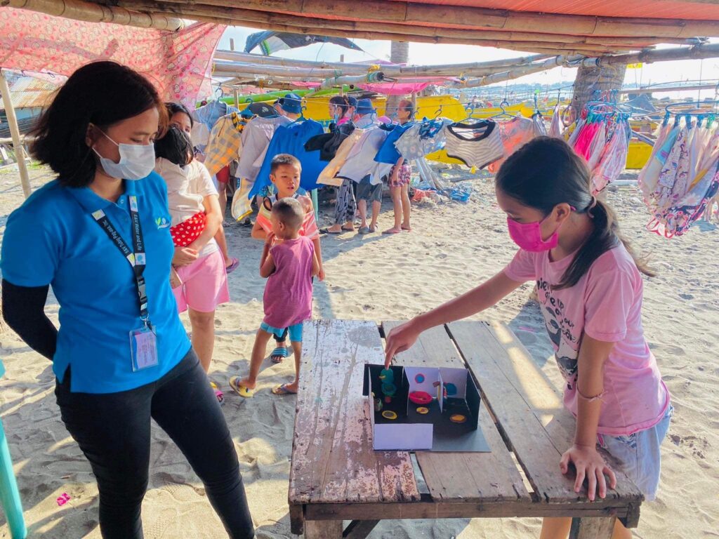 Girl showing a model of a toilet. 