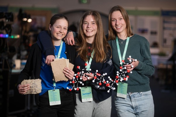 Tre teenage-piger med model af molekyle.