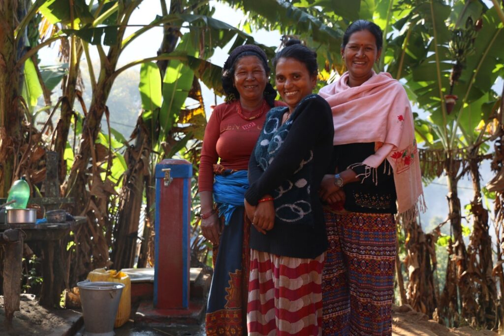 : women from Benighat, Rorang Rural Municipality stand proud in front of one of their household taps. 