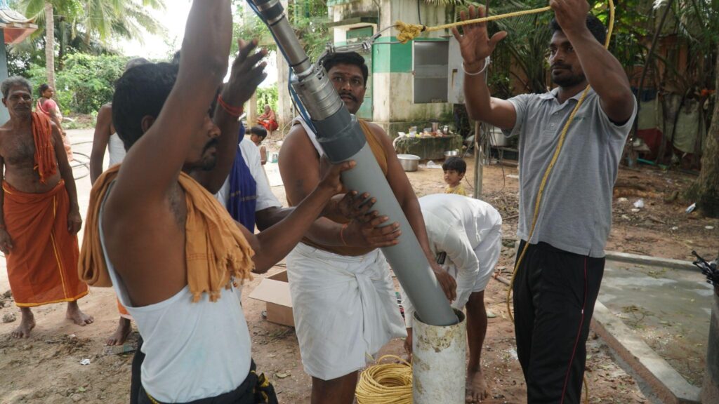 Sunlit Future staff installing pump into the borewell along with village people. Place: Tamil Nadu Credit: Induja Gandhiprasad
