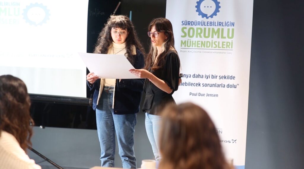 Two young women presenting in front of an audience.