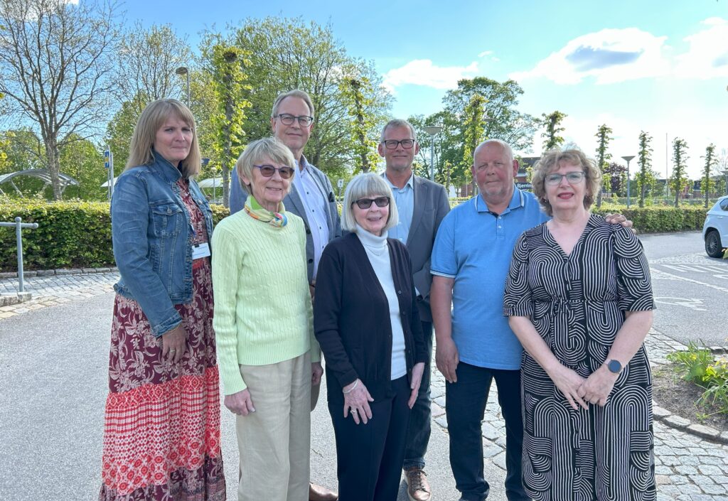Jubilæumsfonden poserer på foto. Fra venstre: Anne-Mette Dahl Knudsen (sekretær) og de seks bestyrelsesmedlemmer: Estrid Due Hesselholt, Mogens Lindhard (formand), Ingermarie Due Nielsen, Torben Ømark, Kurt Mikkelsen og Ritta Søe Kastrup. Herudover tæller bestyrelsen også Hans Henrik Gaardsøe.