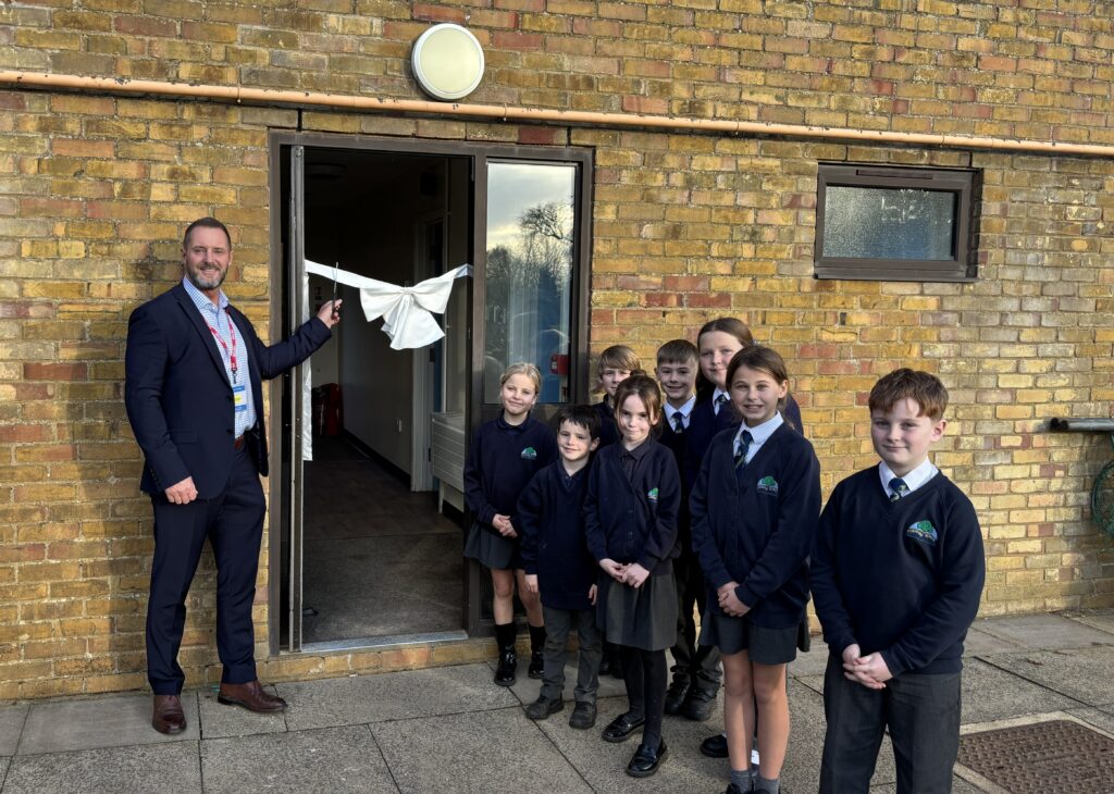 Group of adults and children in front of school building